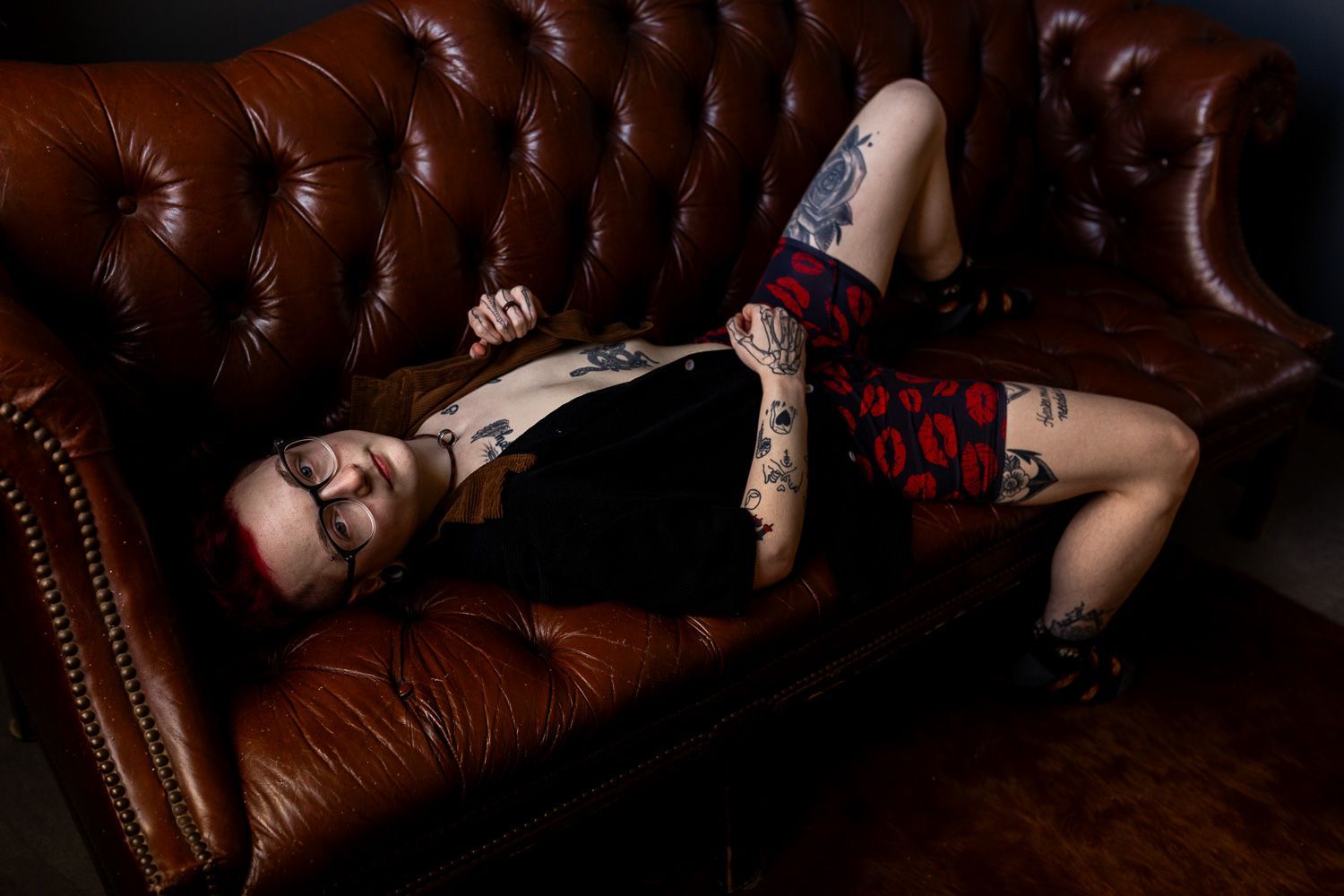 Trans man posing on brown couch with 