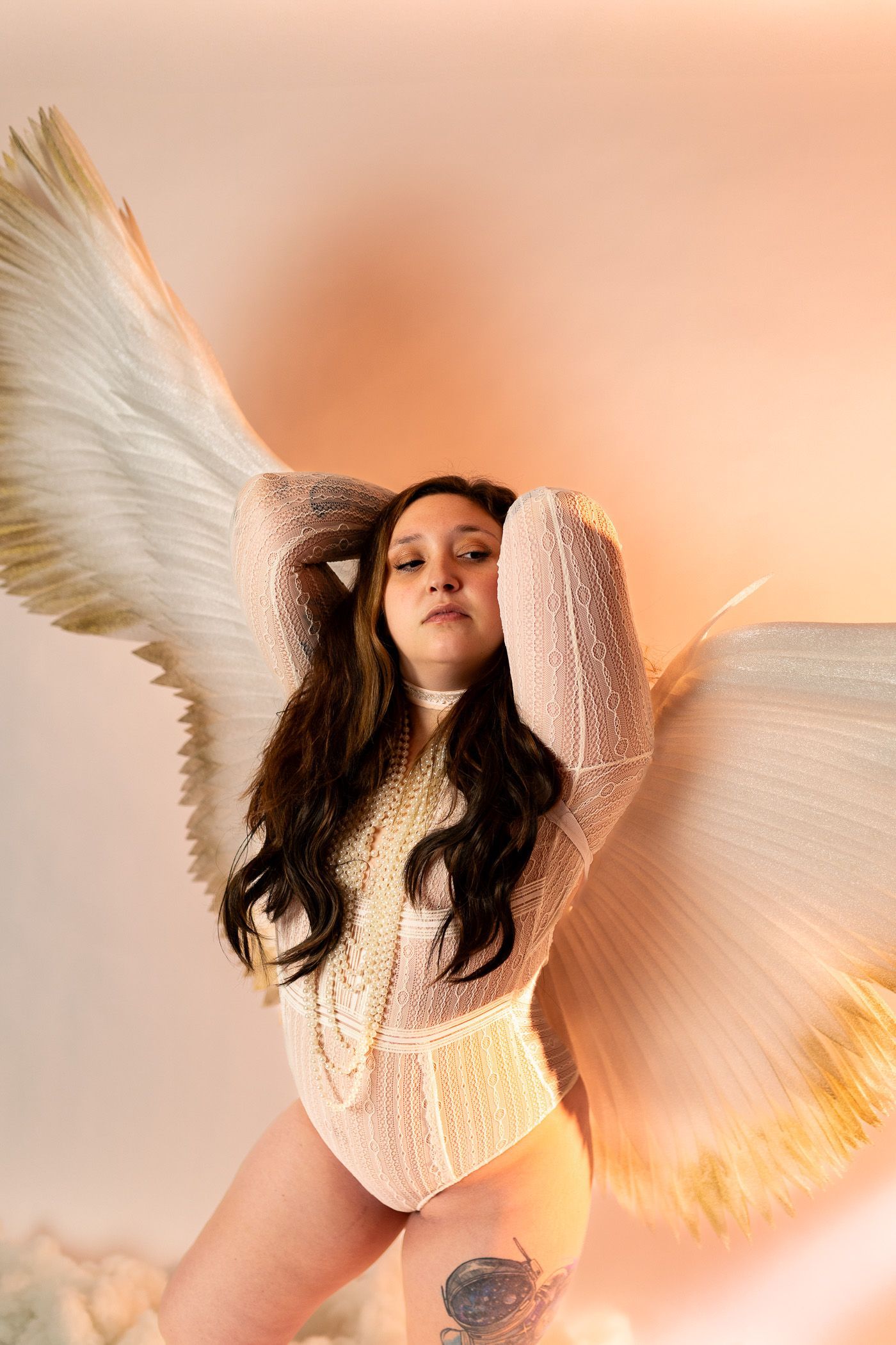 Woman posing in lingerie for boudoir session with angel wings