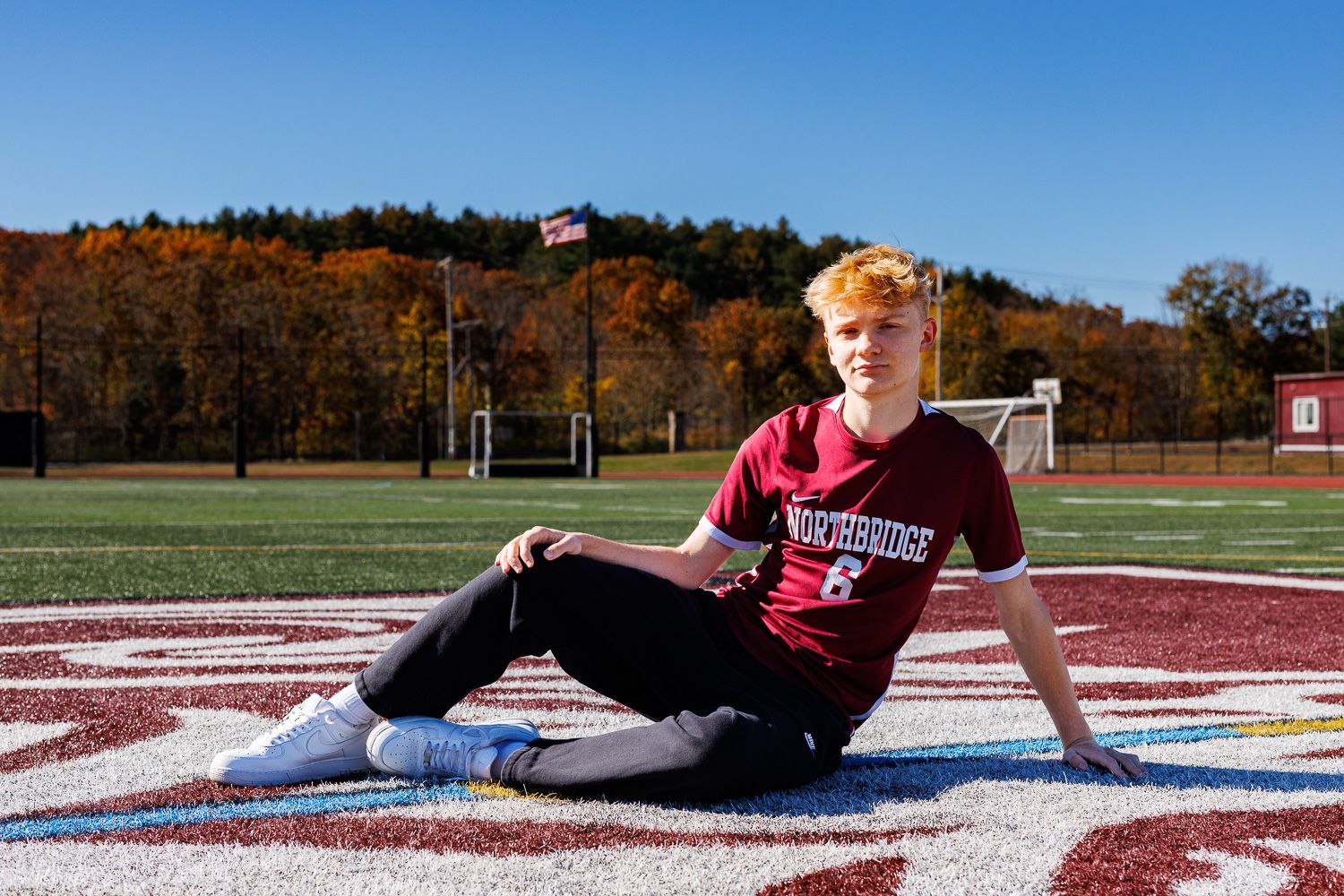 High school senior - senior photography - male student posing on soccer field with soccer jersey