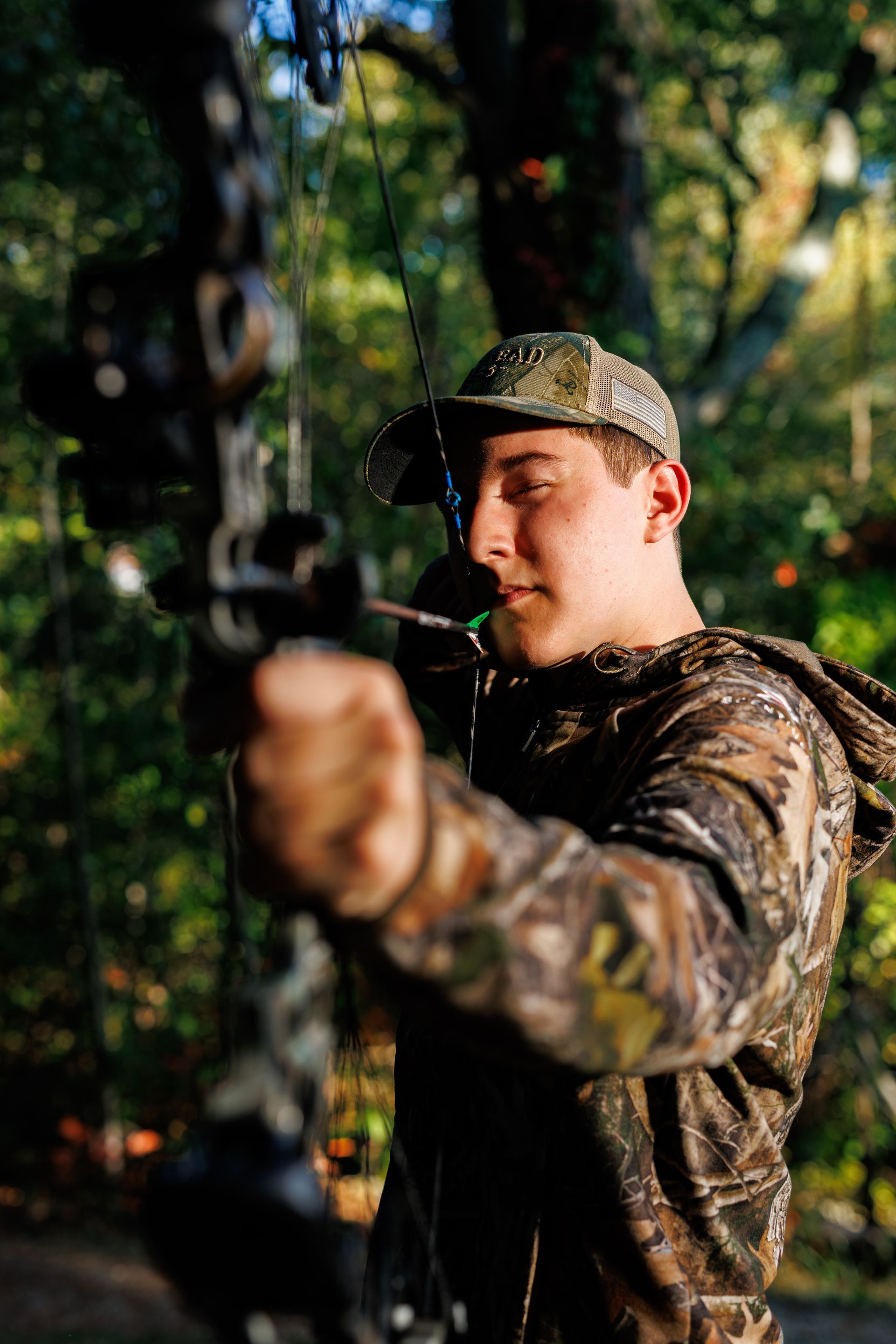 High school senior - senior photography - male student with bow and arrow in camo
