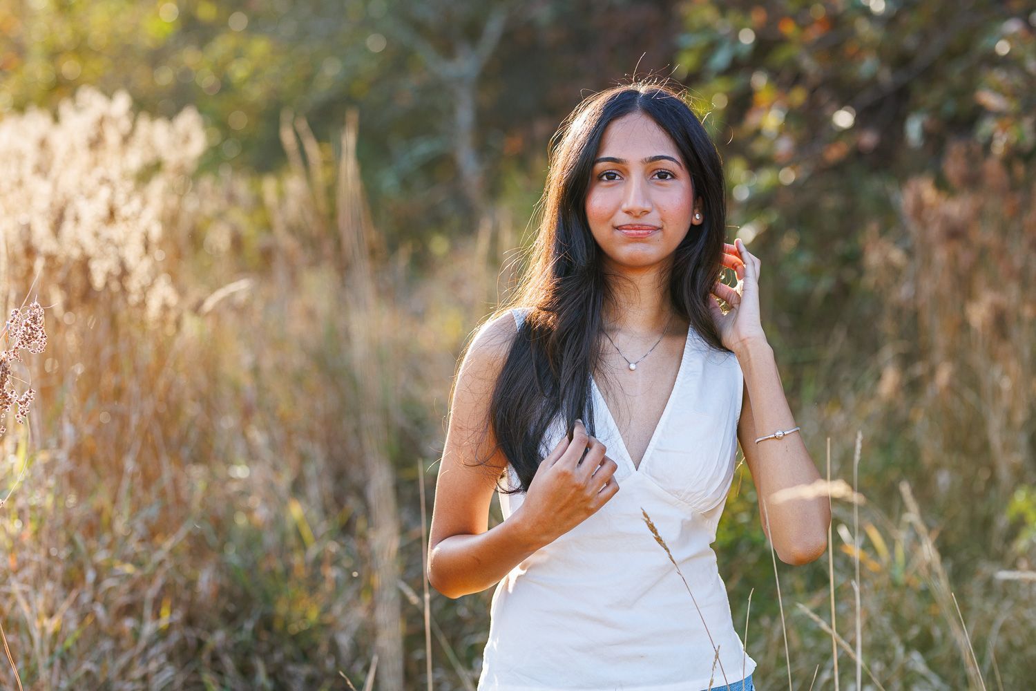 High school senior - senior photography - female student posing in field backlit by the sun