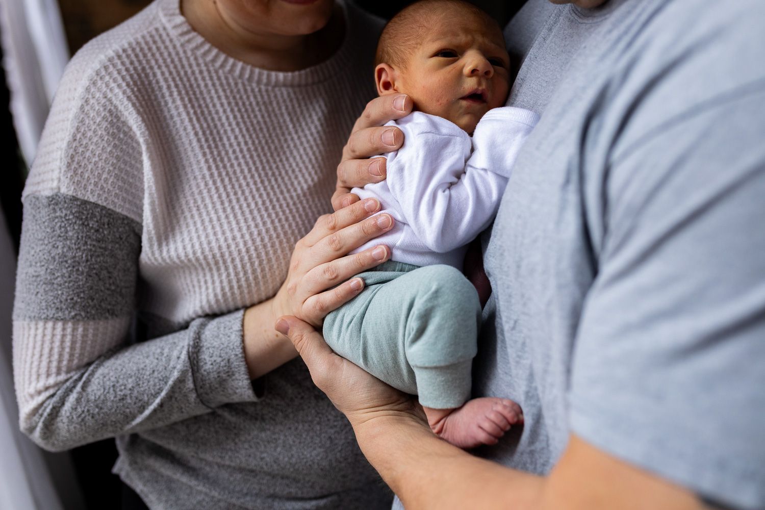 Newborn photography baby boy snuggled with parents