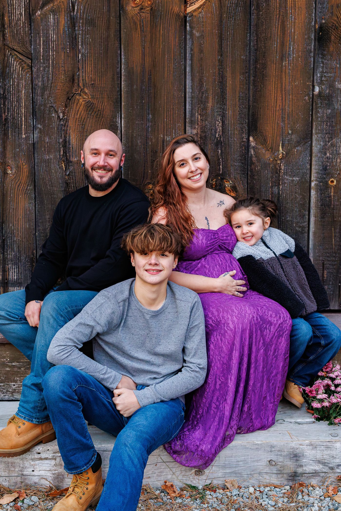 Maternity photography family posing in front of barn