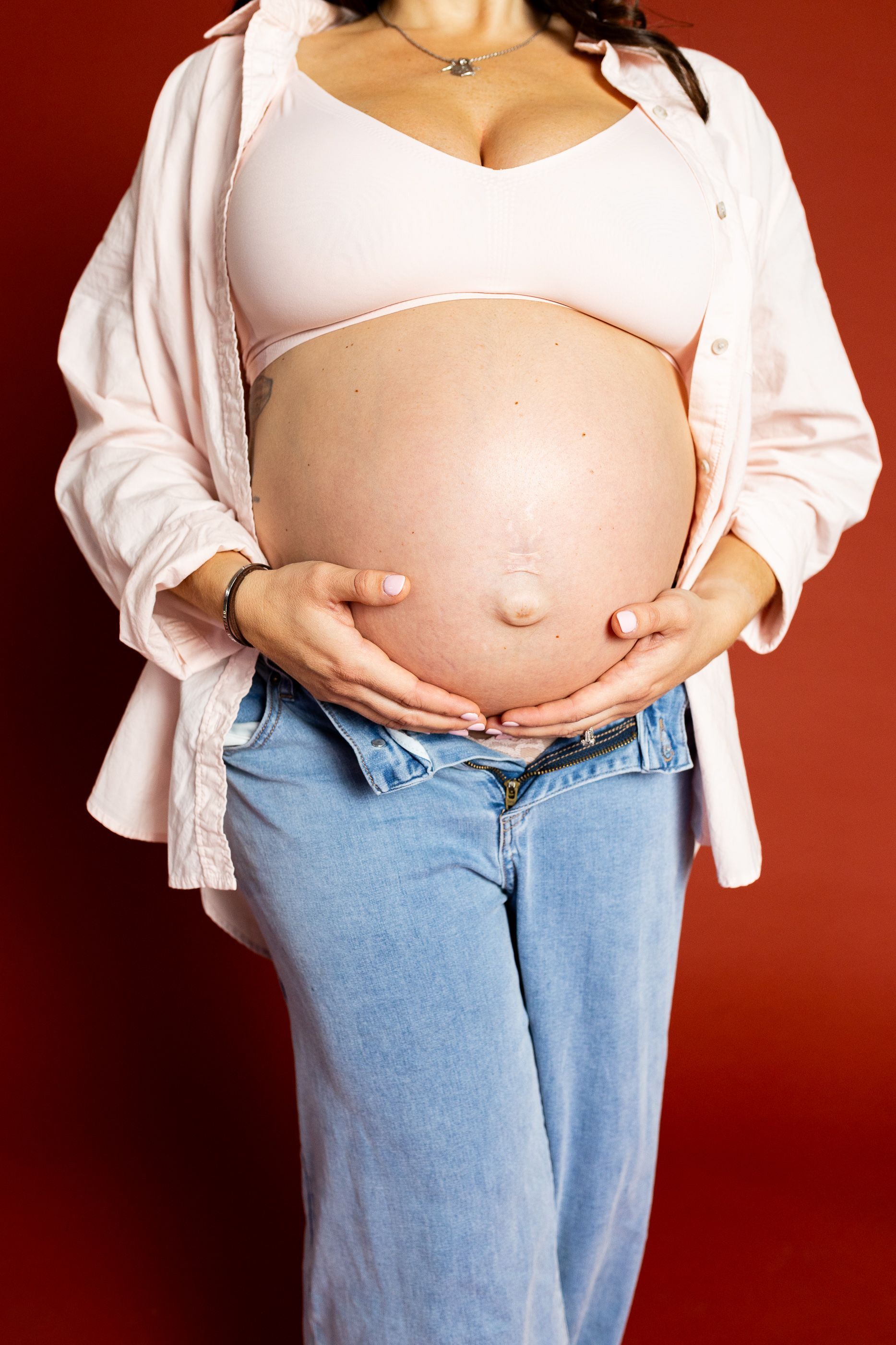 Maternity photography mom sitting while holding her belly