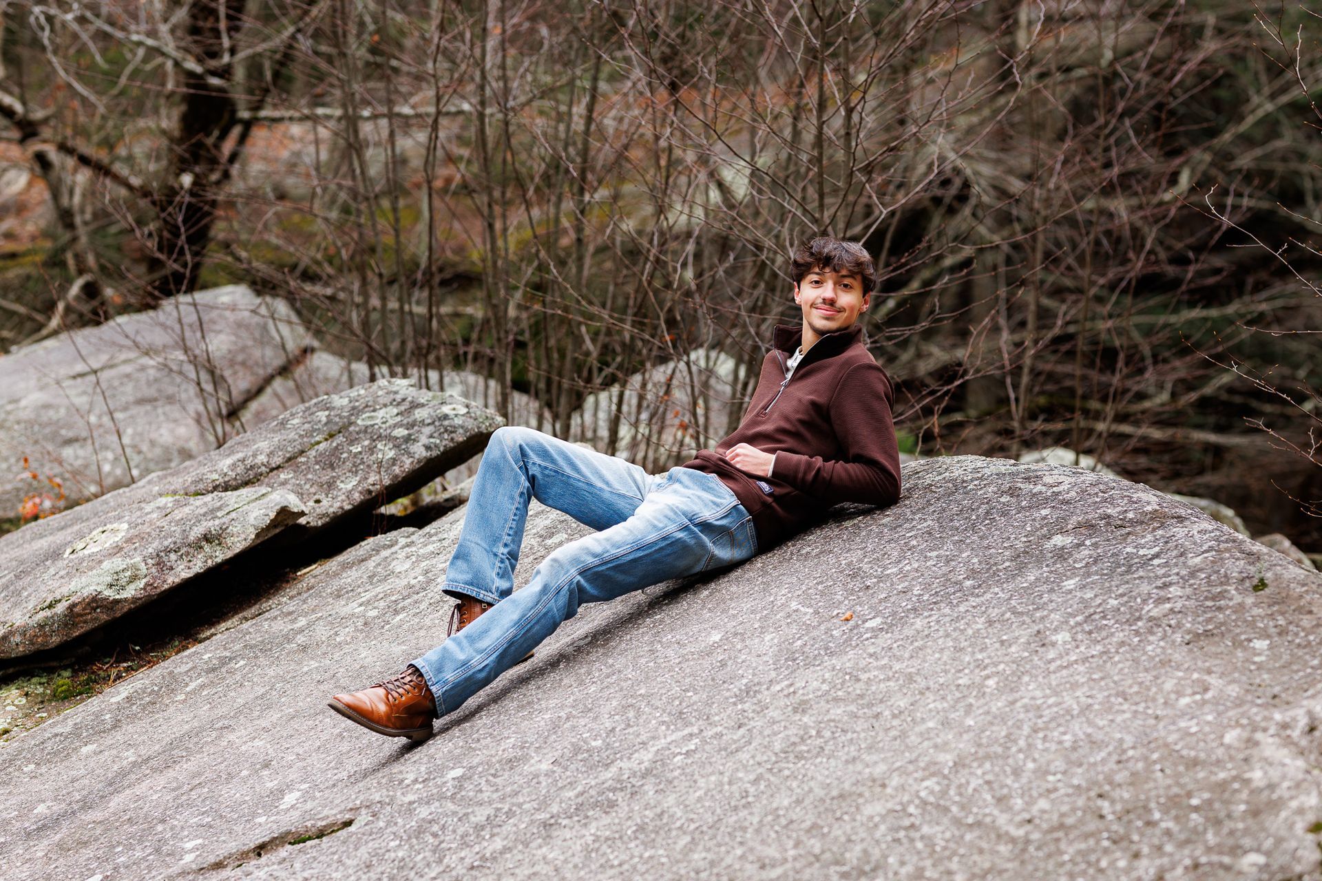High school senior - senior photography - male student lounging on rock