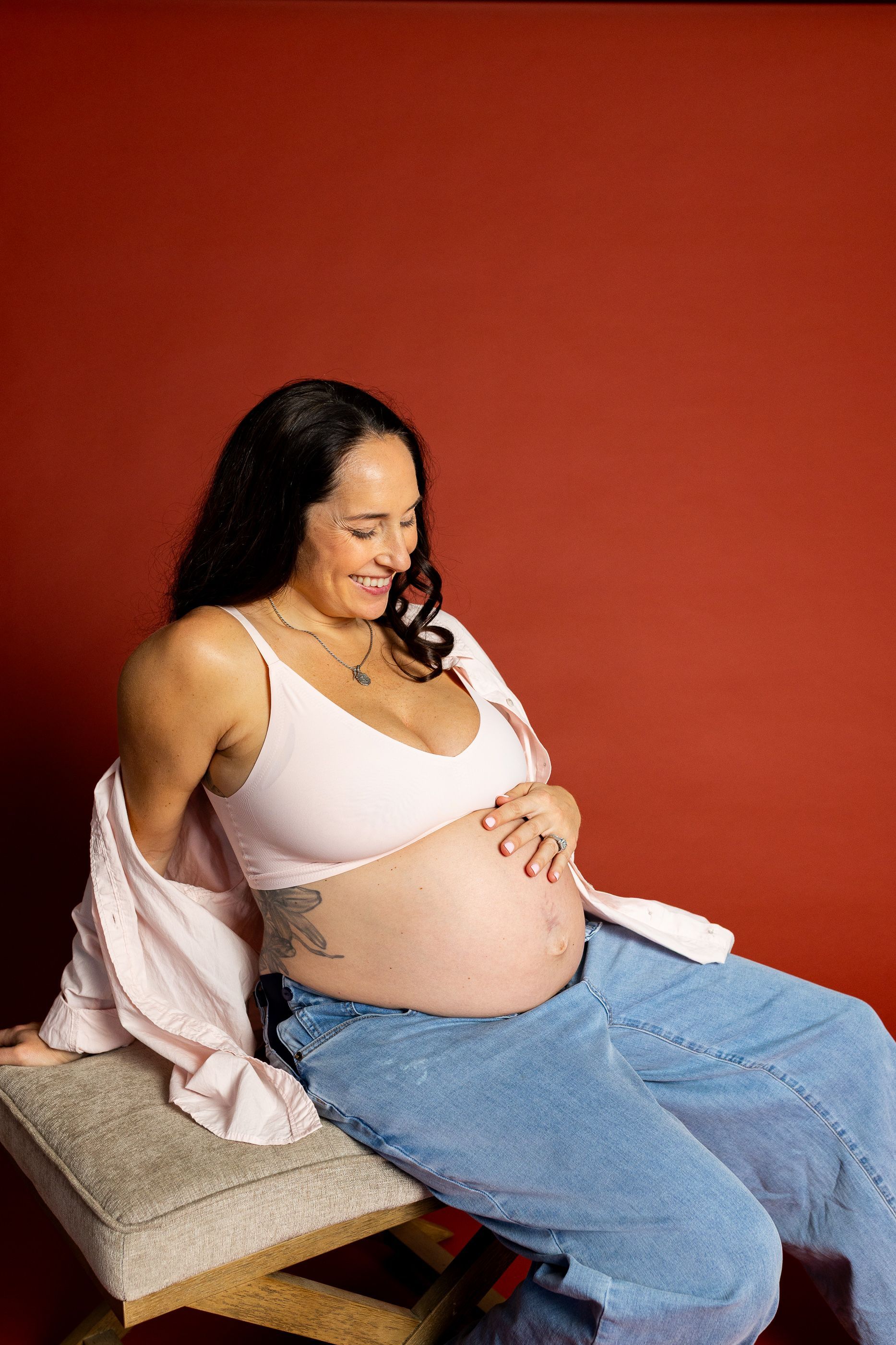 Maternity photography mom sitting while holding her belly