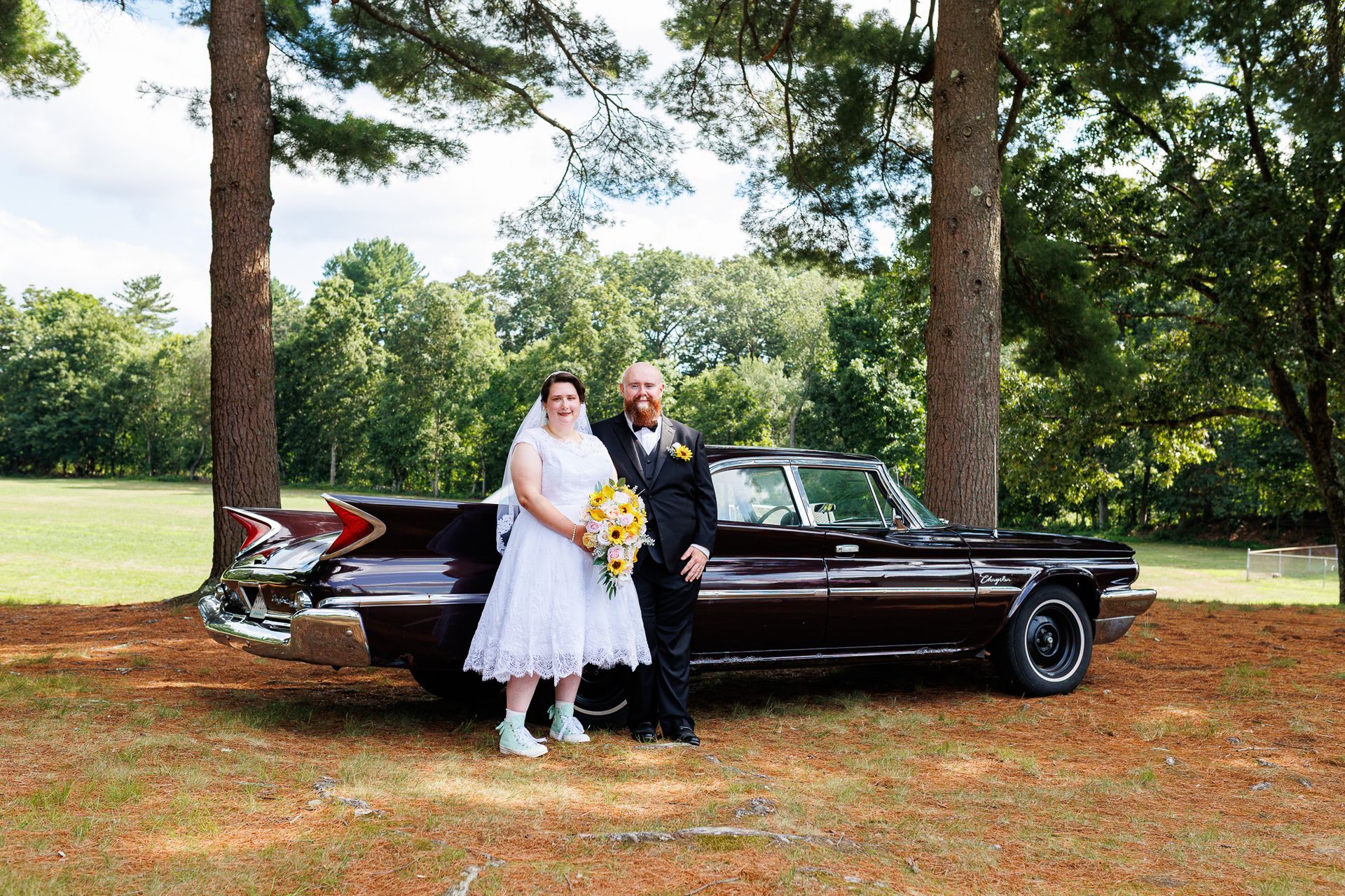 bride and groom posing in front of antique Chevy