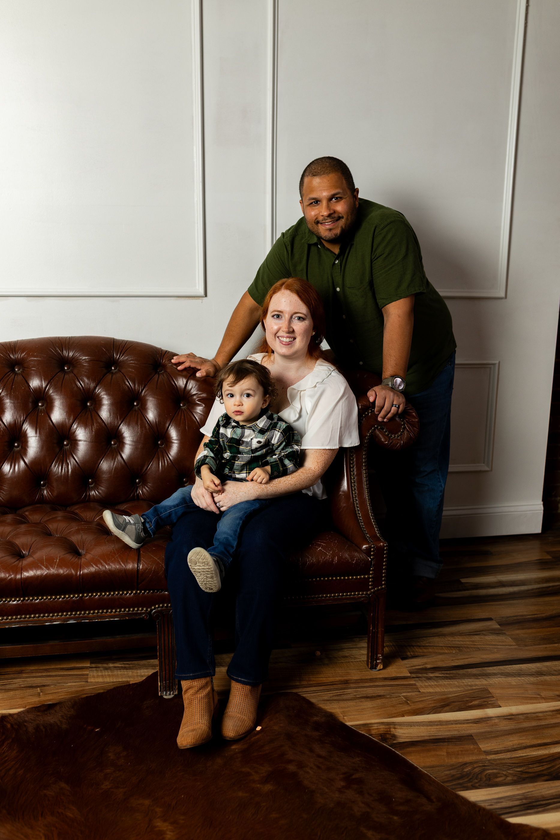 A family is sitting on the steps of a building with a dog.