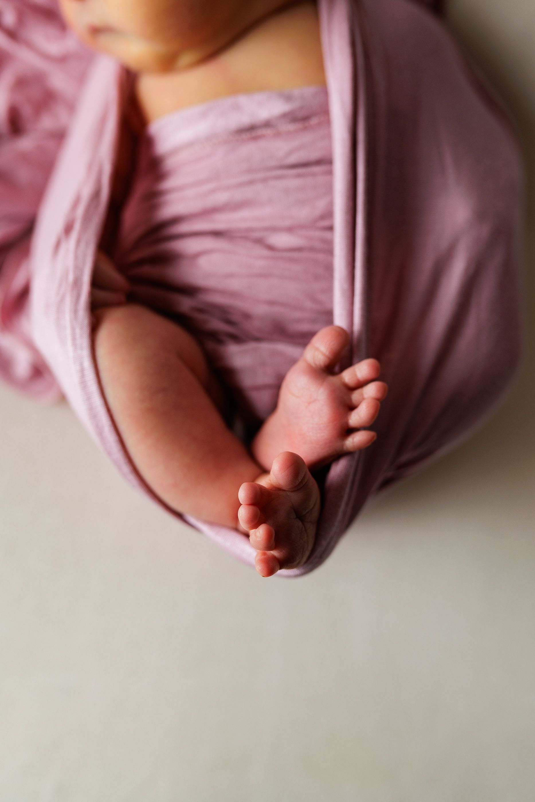 Newborn photography baby girl swaddled toes exposed