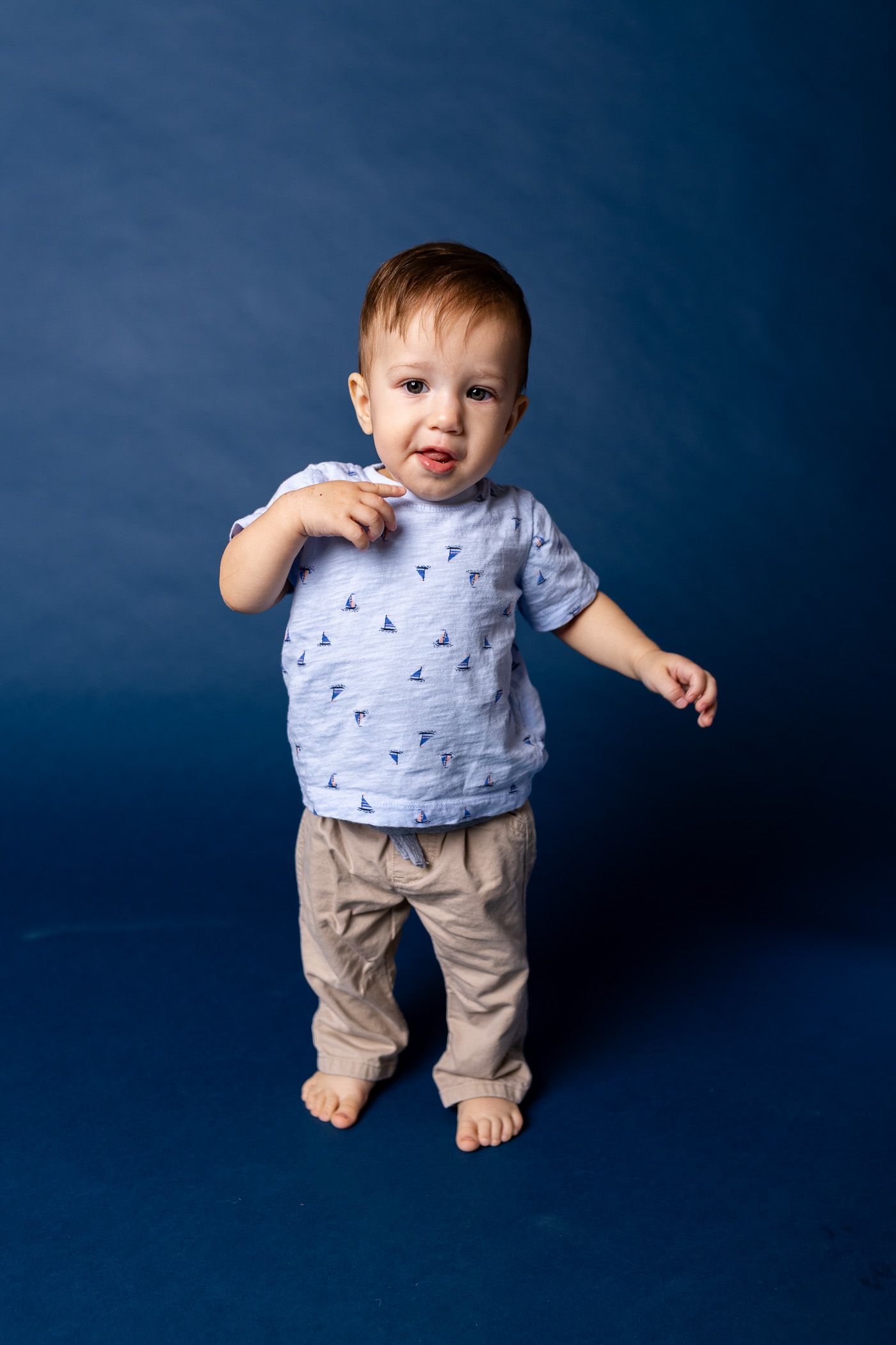 Baby posing on blue background for cake smash session