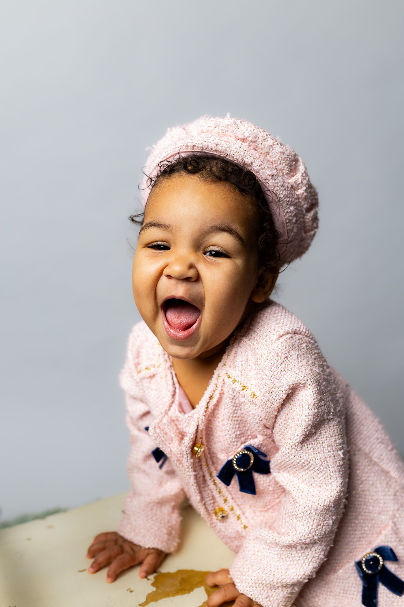 Baby posing on grey background for cake smash session