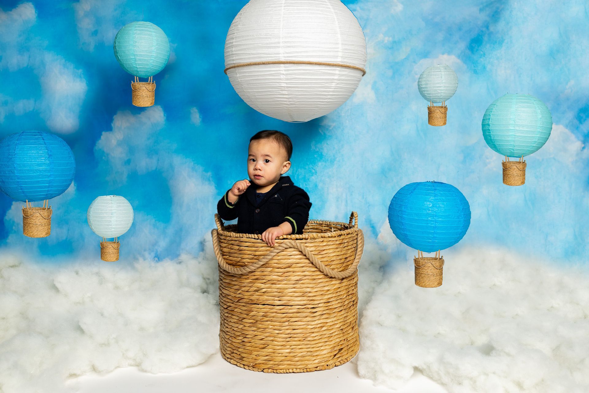 baby on a hot air balloon themed set for cake smash session