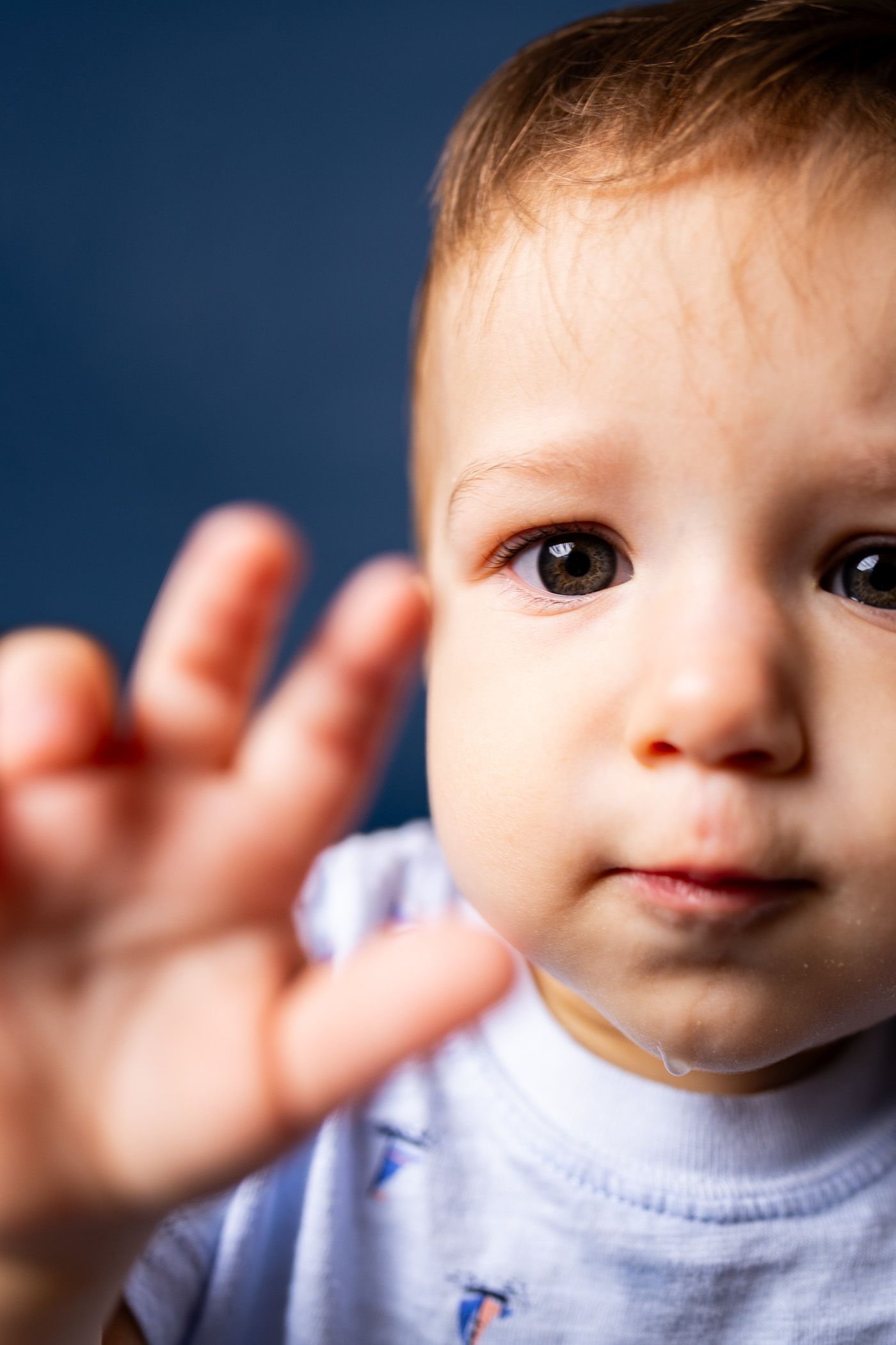 Baby posing on blue background for cake smash session