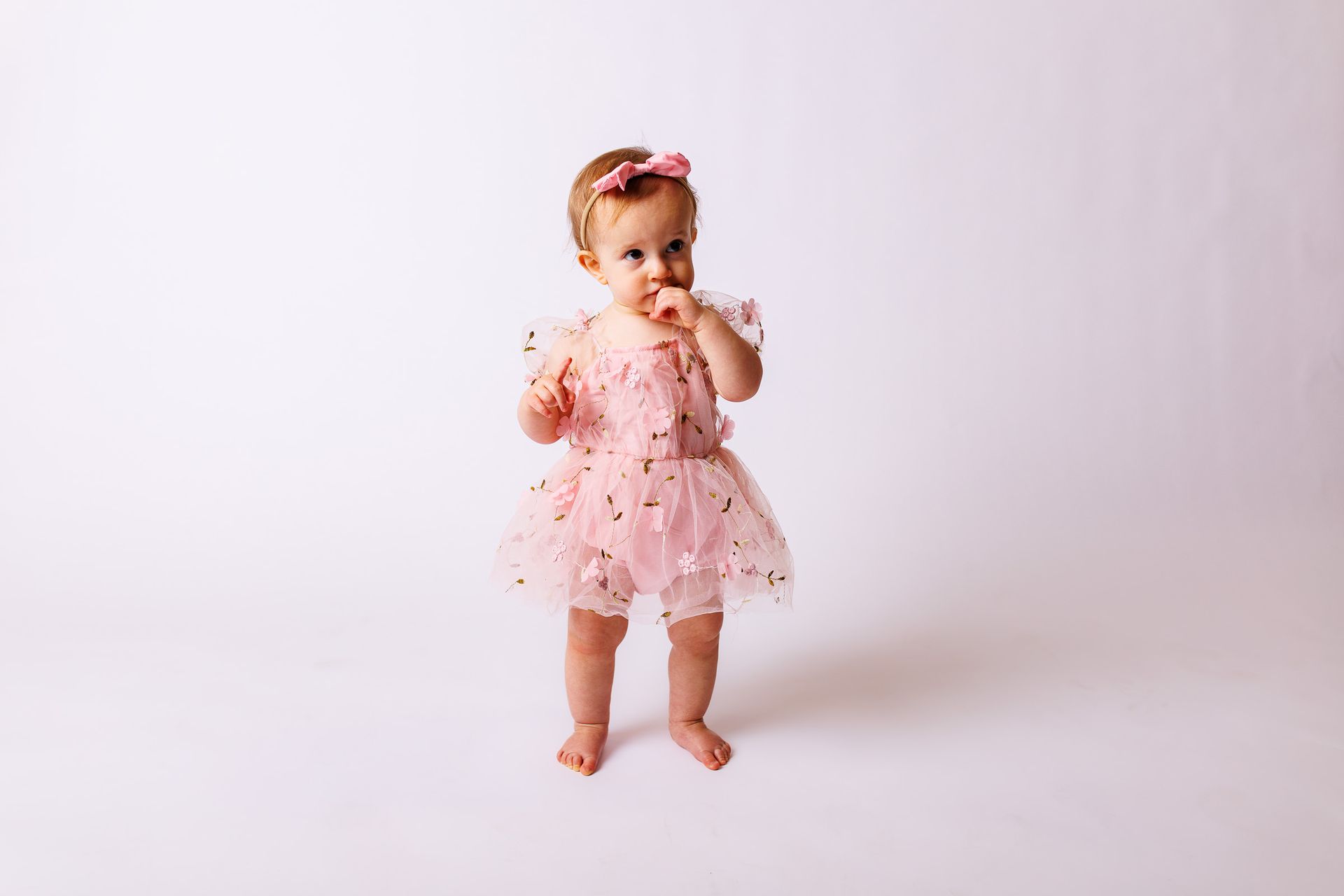 Baby posing on white background for cake smash session