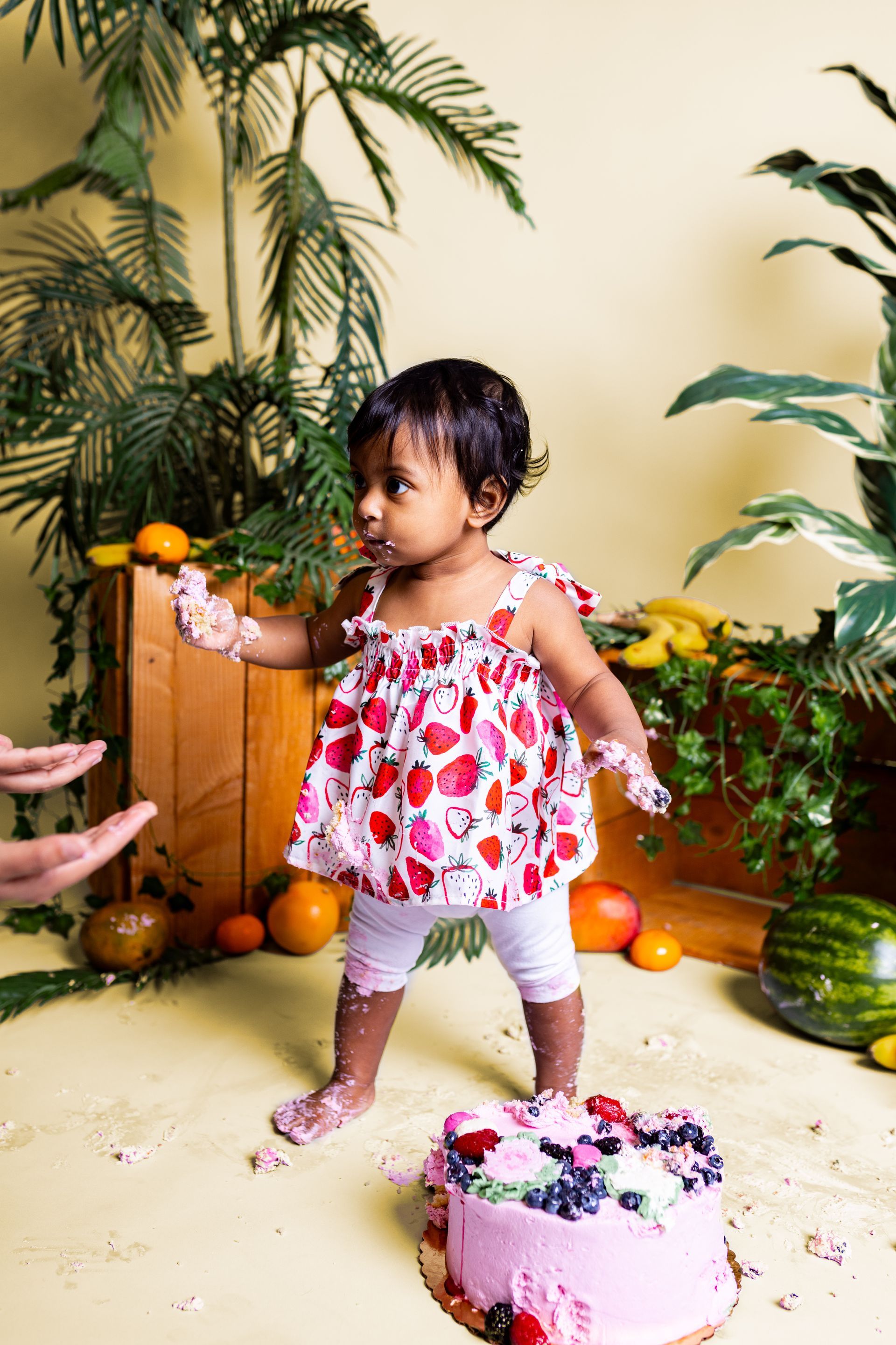 Baby posing on yellow background for citrus and jungle themed cake smash session