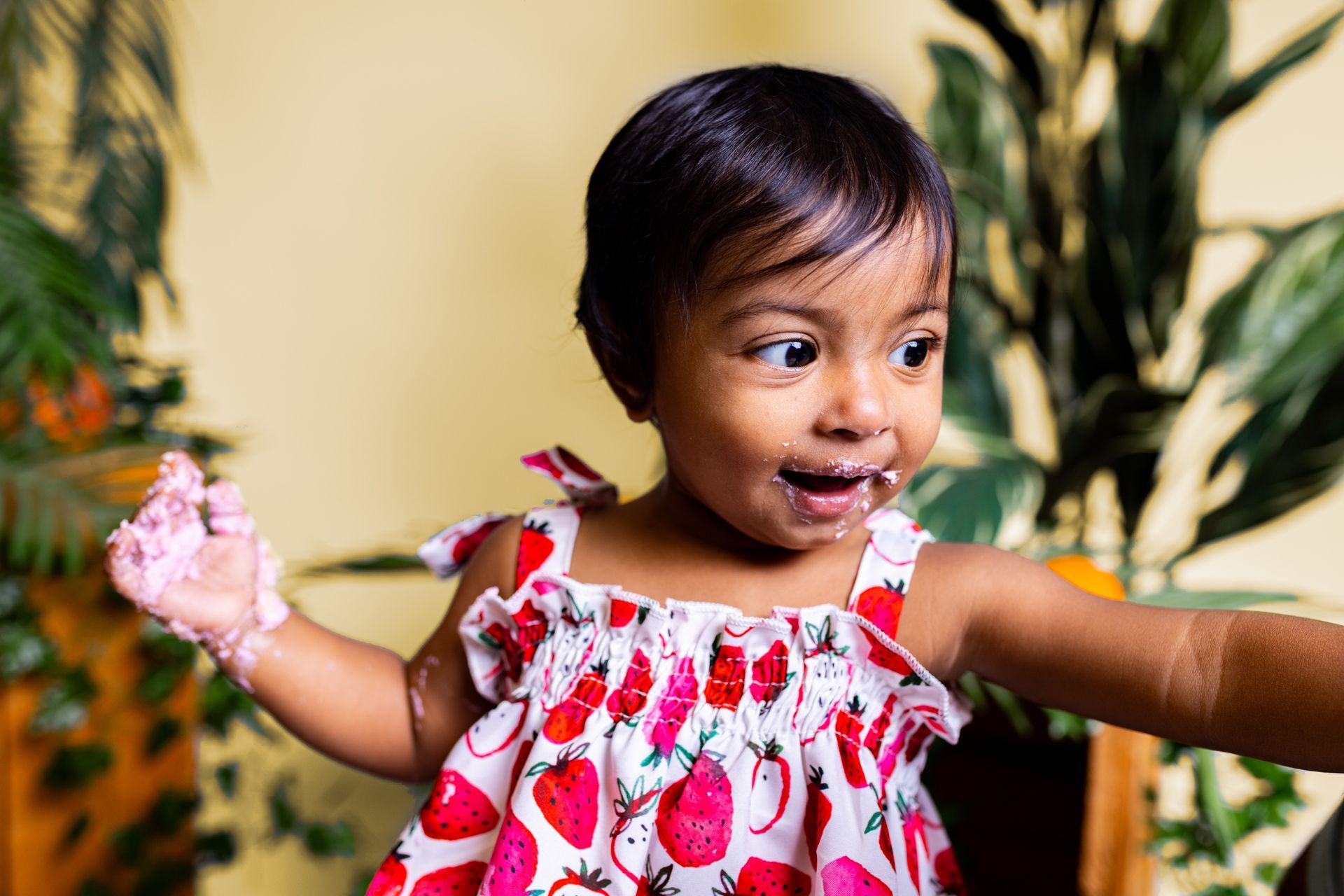 Baby posing on yellow background for citrus and jungle themed cake smash session
