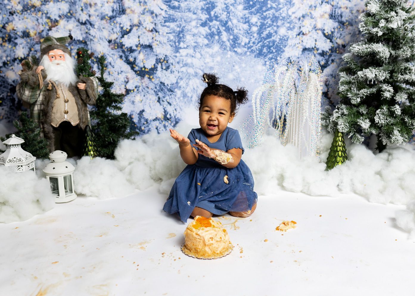 A little girl is sitting on the floor with a cake in her hand.