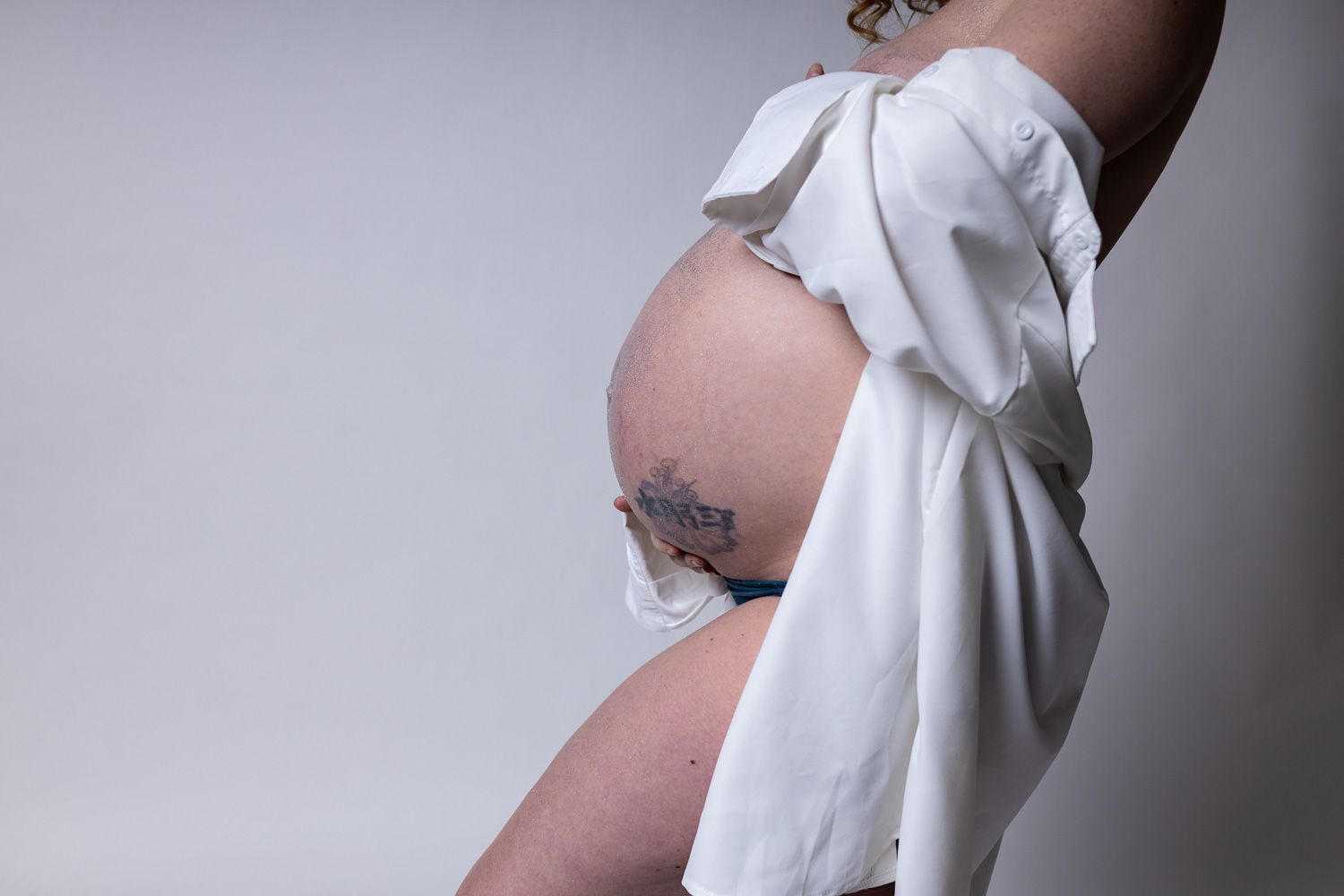 Maternity photography mom posing in milk on white background and close up of belly
