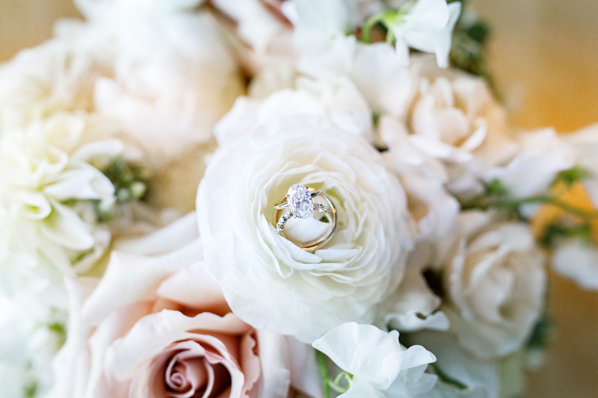 close up of wedding rings in flowers