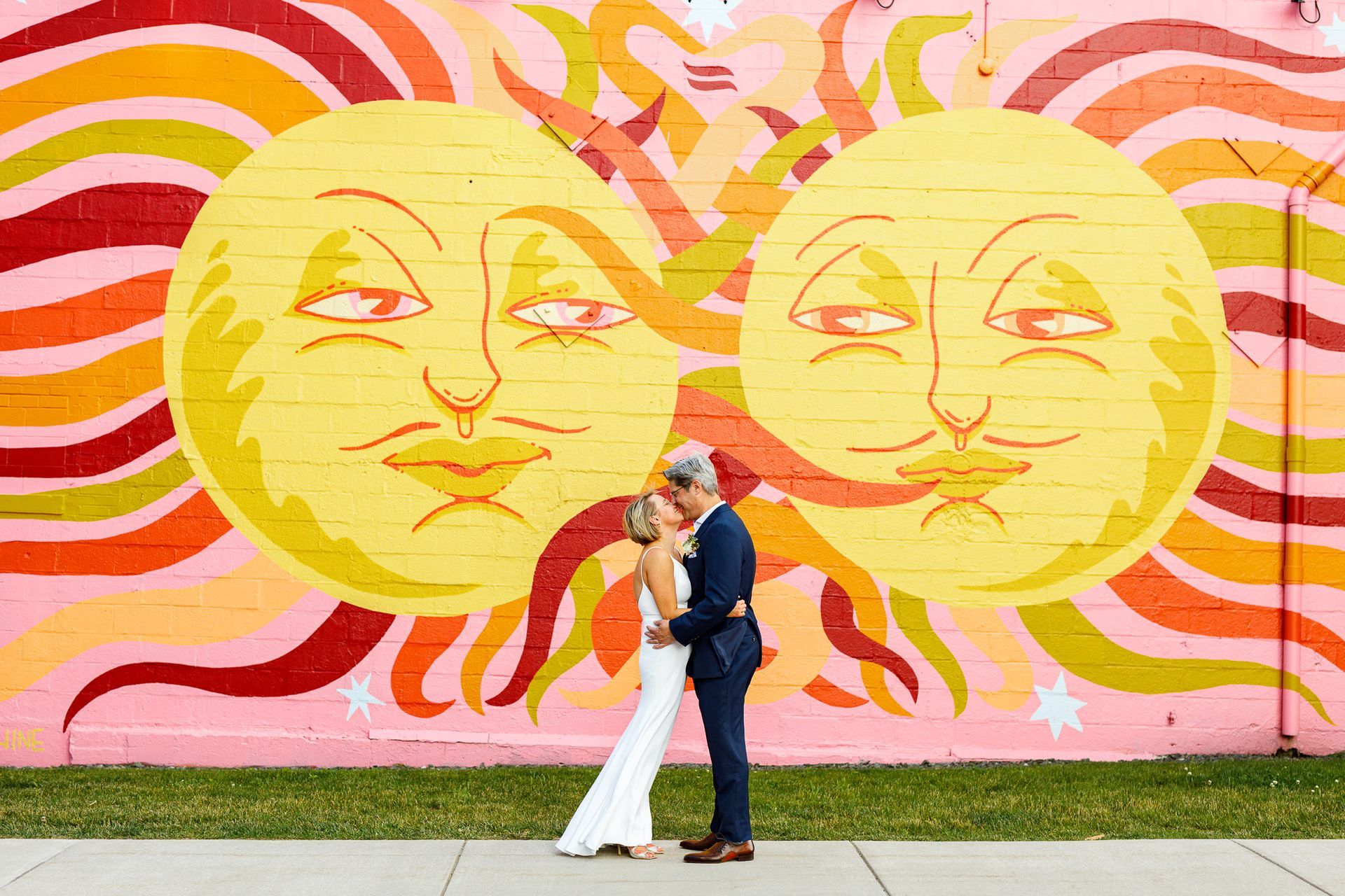 couple posing in front of sun mural in Providence, RI