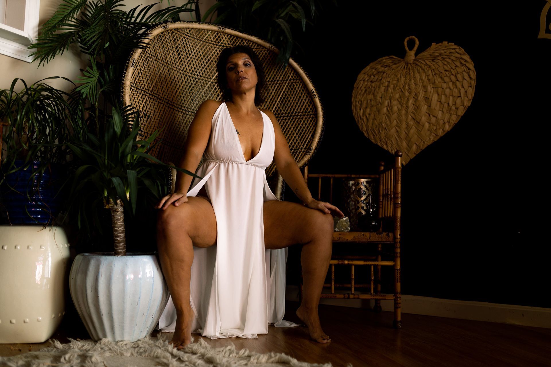 Woman posing in lingerie for boudoir session sitting in a peacock chair