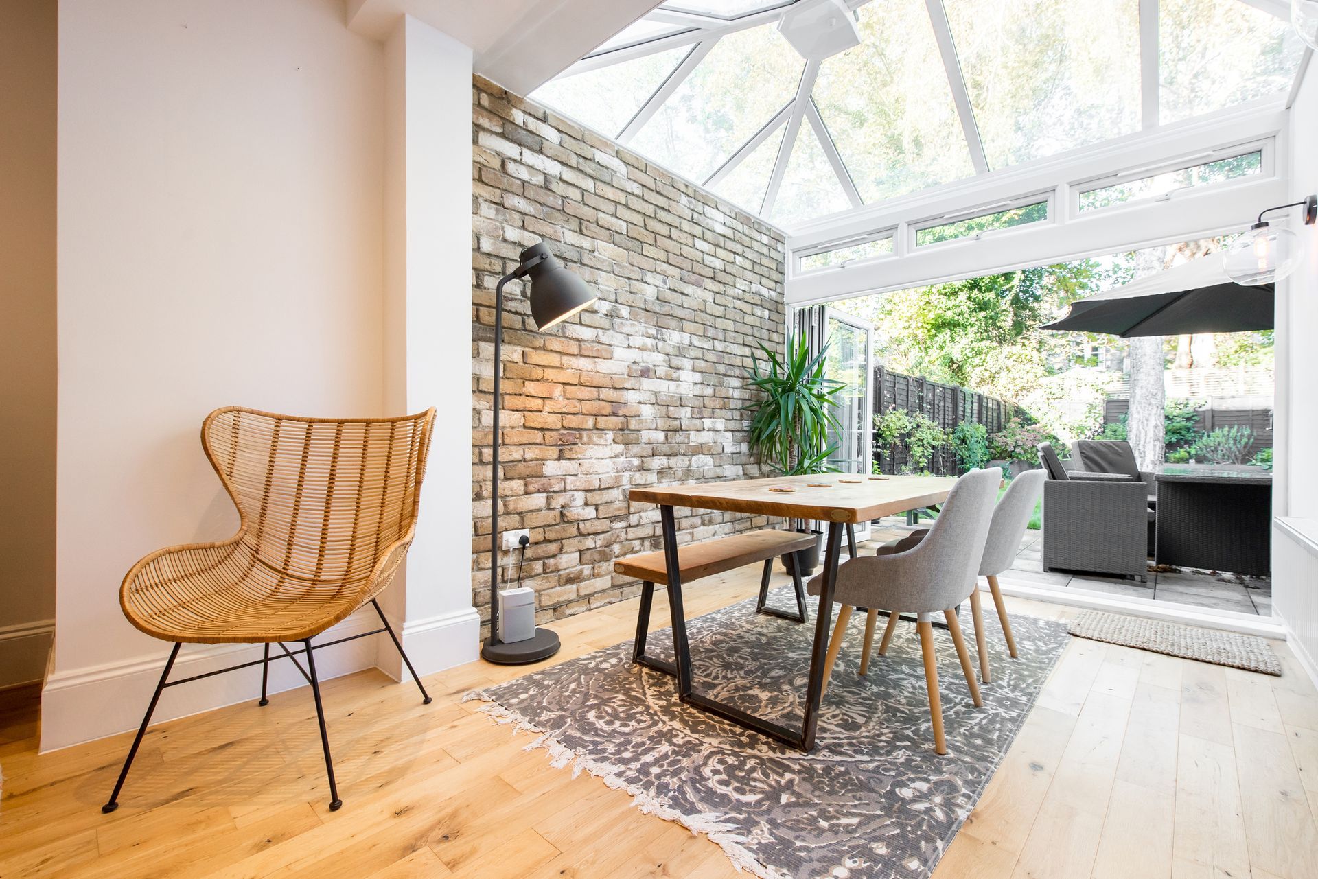 A dining room with a table and chairs and a rug.