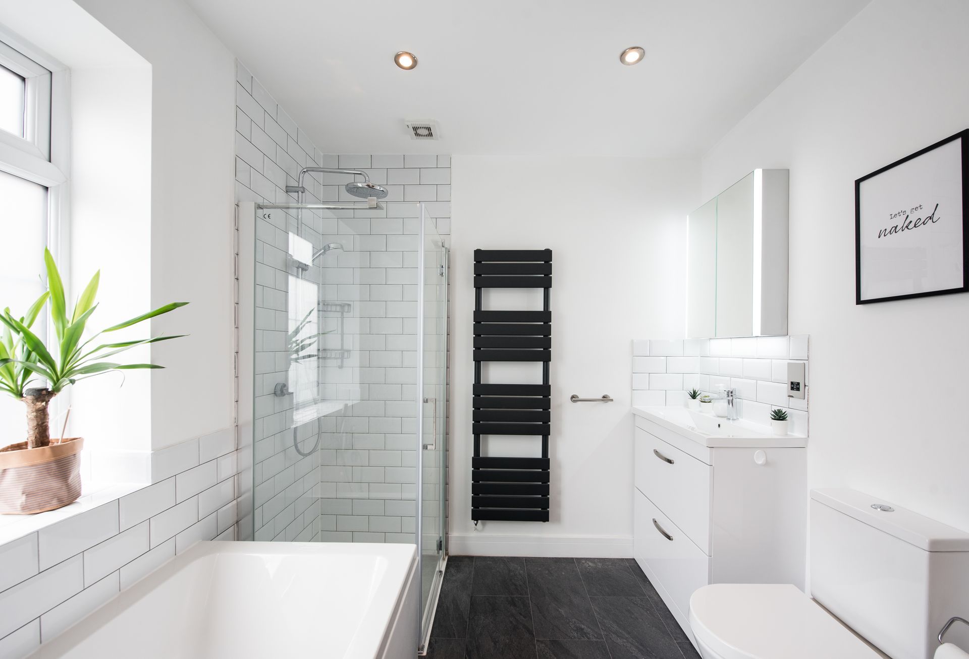 A bathroom with a bathtub , sink , toilet and walk in shower.