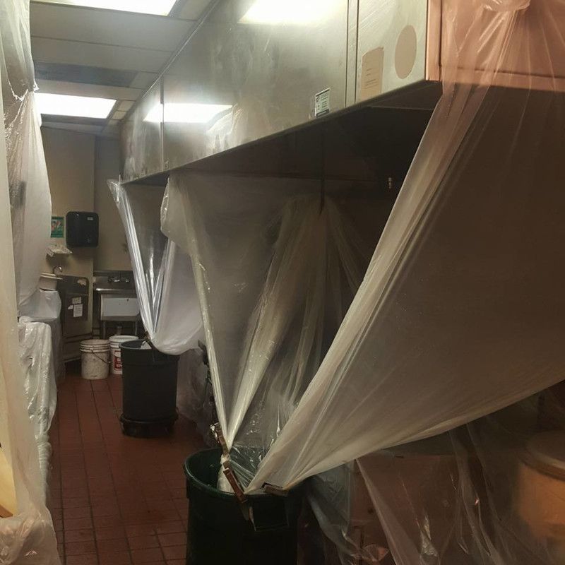 Dim kitchen with counters covered in plastic sheeting during renovation
