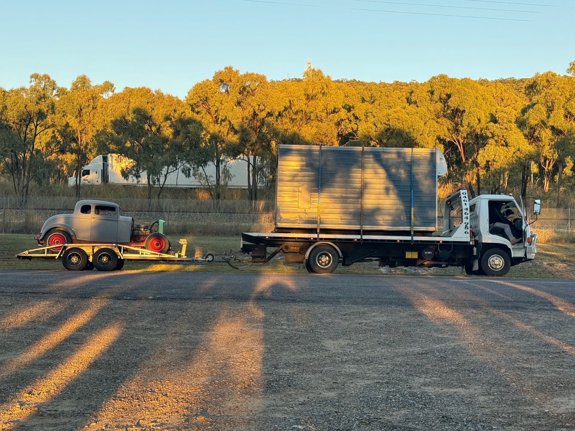 A Flatbed Truck Towing a Classic Car on a Trailer — B&D Auto Group & Towing in Collinsville, QLD
