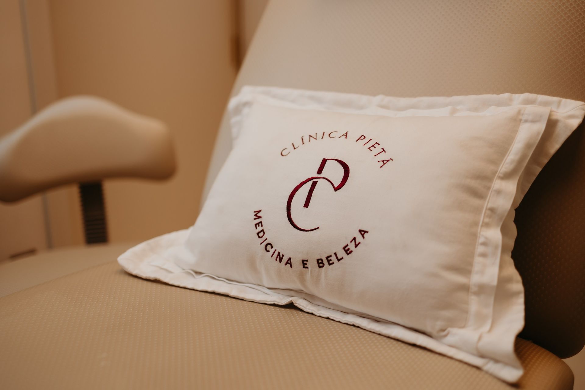 Almofada branca com o logo da empresa com a inscrição 
