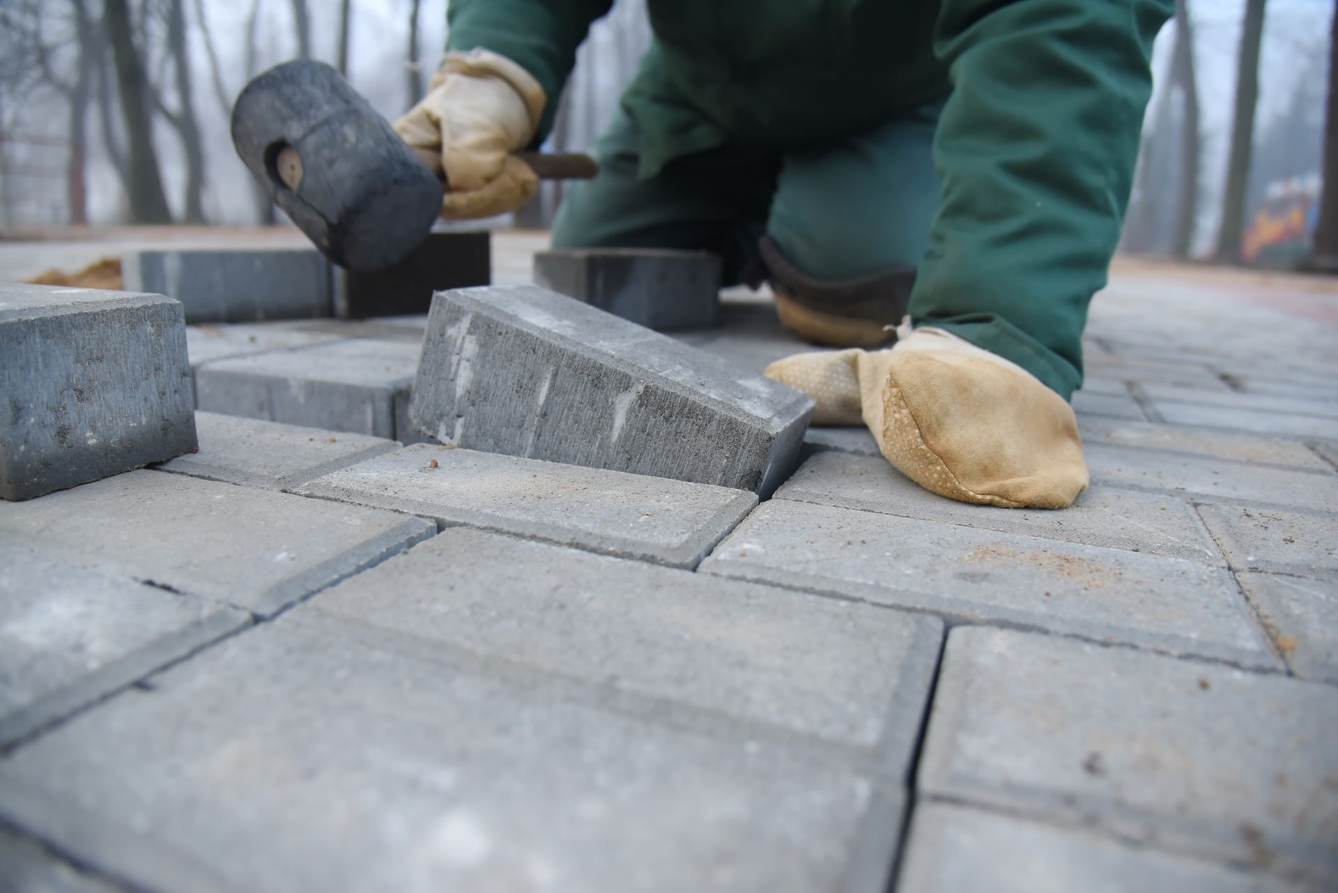 A man lays paving slabs and repairs a road. A man lays paving slabs and repairs a road.
