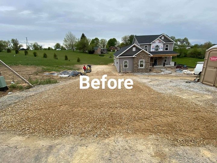 Construction site with gravel driveway leading to a partially built house and garage, before construction.