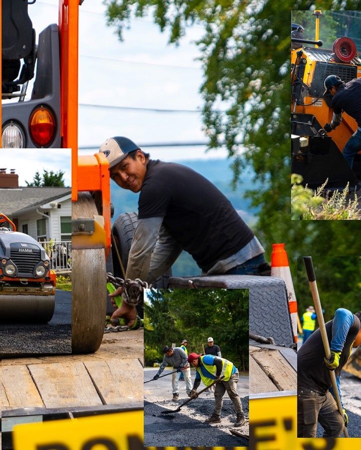 Road crew paving asphalt: man smiles by equipment; others use shovels and operate machinery on sunny day.