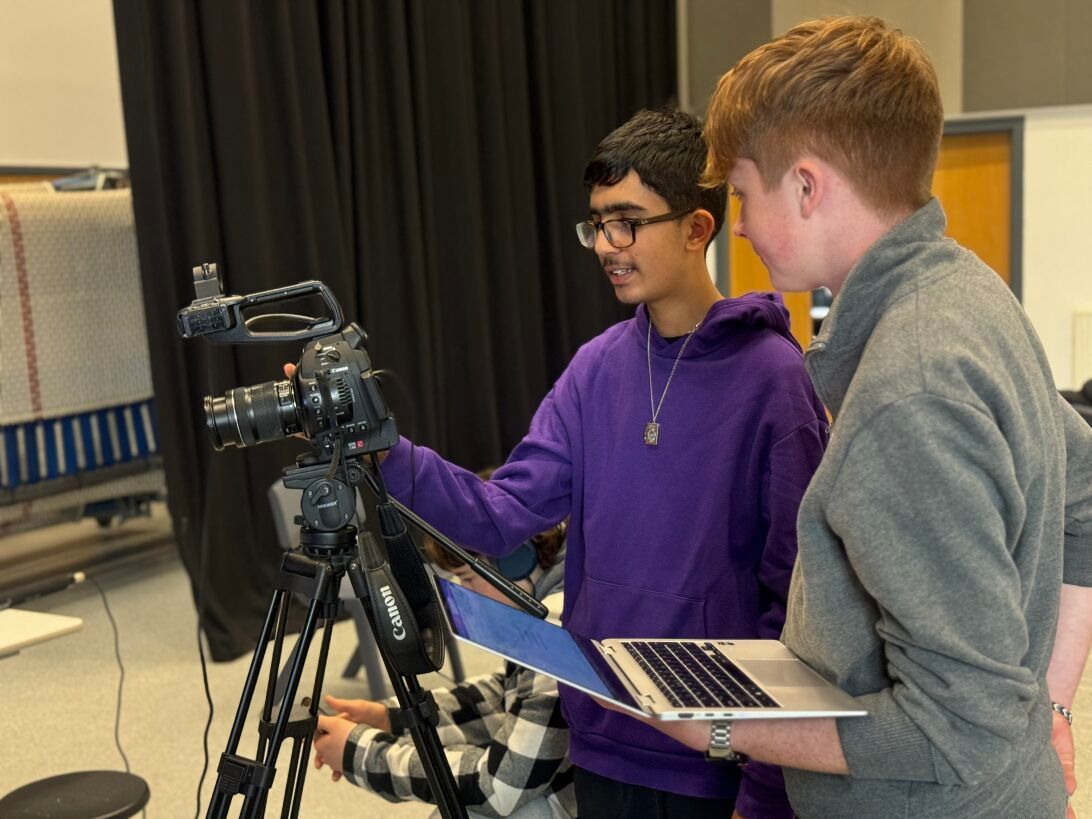 Film Industry Training | Two boys are looking at a camera while one holds a laptop