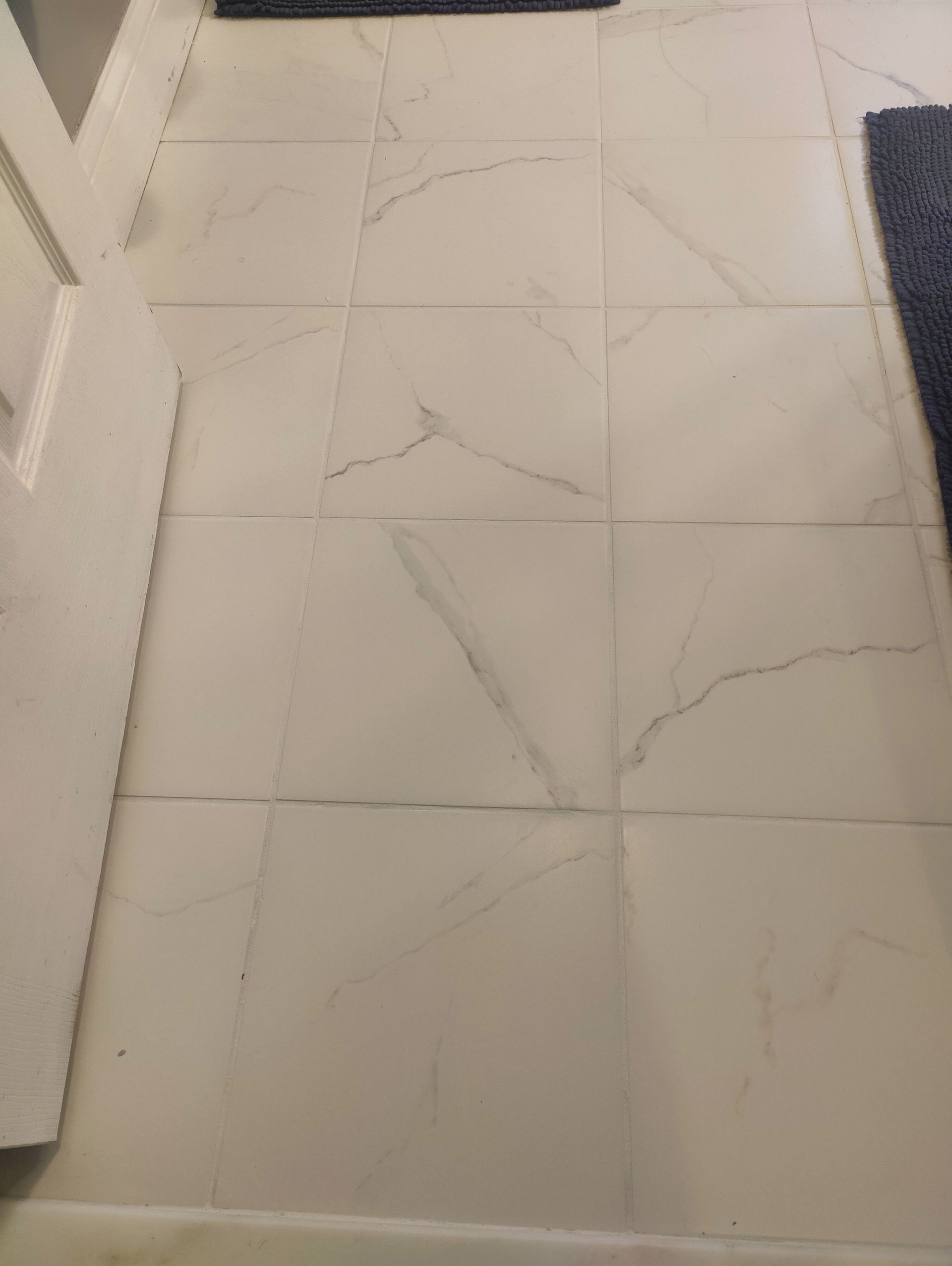White tile floor with dark grout lines and a marble-like pattern.