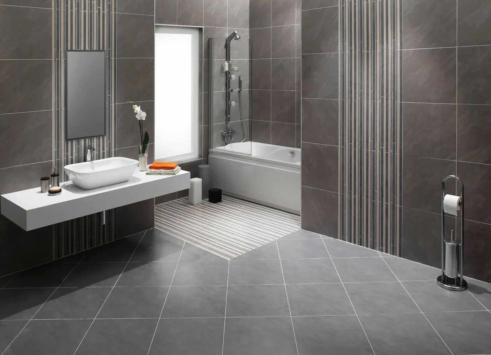 Modern gray bathroom with floating vanity, bathtub, shower, and decorative tile.