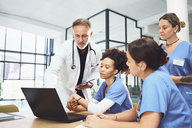 Medical team reviewing a laptop together in a bright office