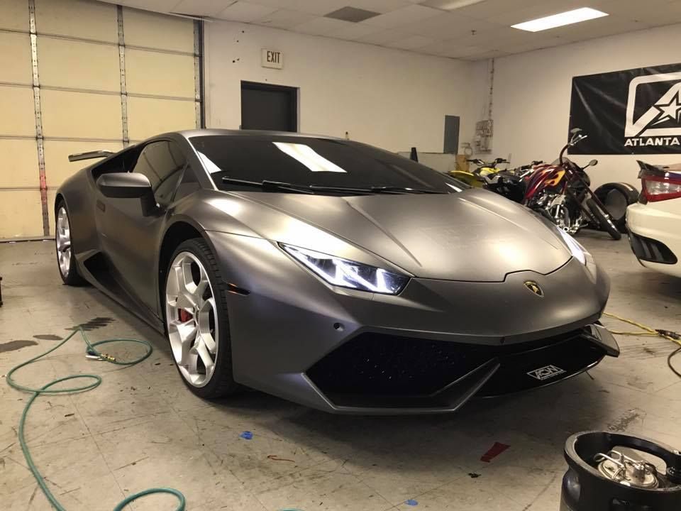 Gray Lamborghini Huracan in a garage, matte finish, red brake calipers.