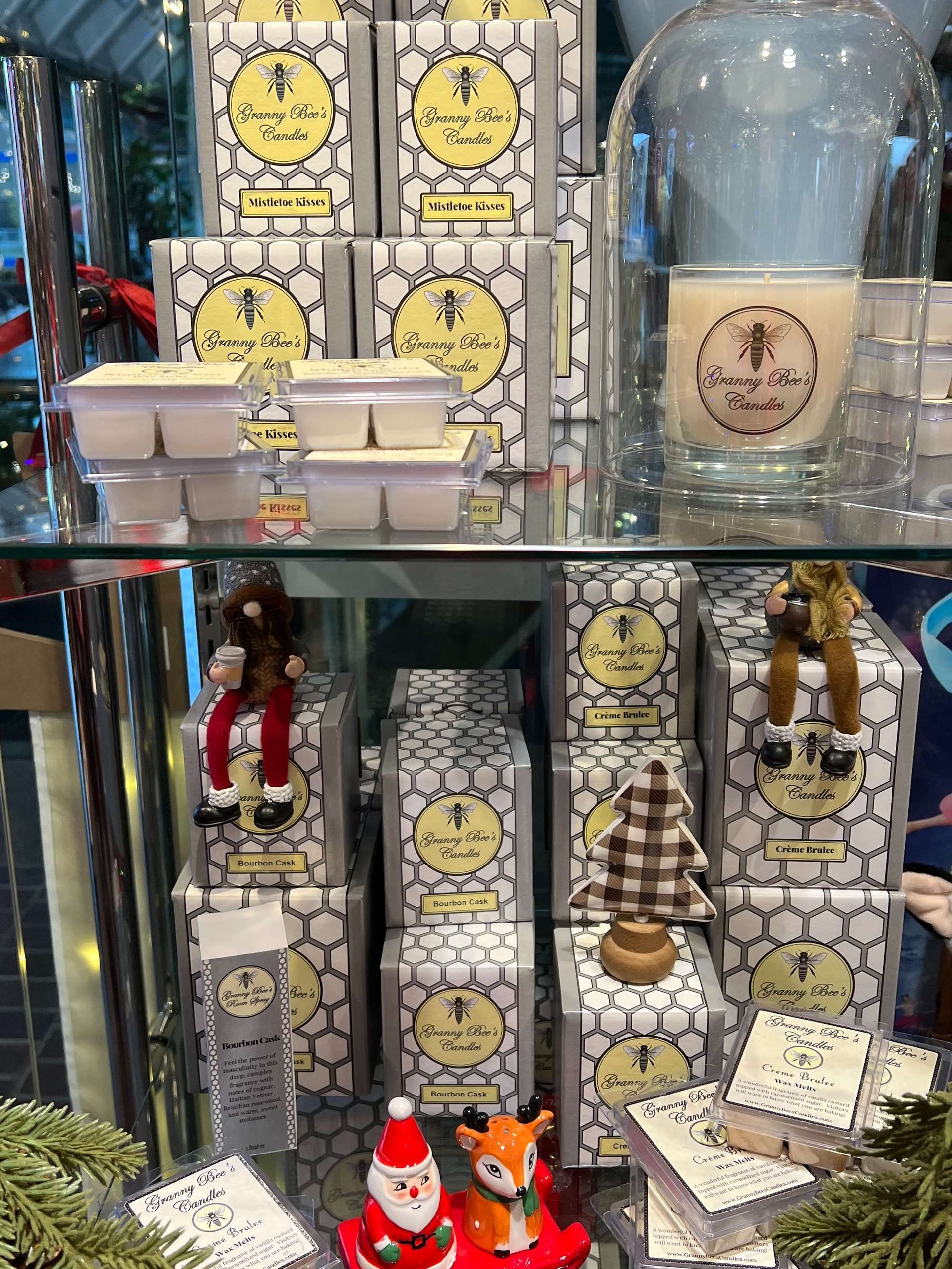 Store shelf with yellow packaged goods, a glass jar, and small holiday figurines in a display case