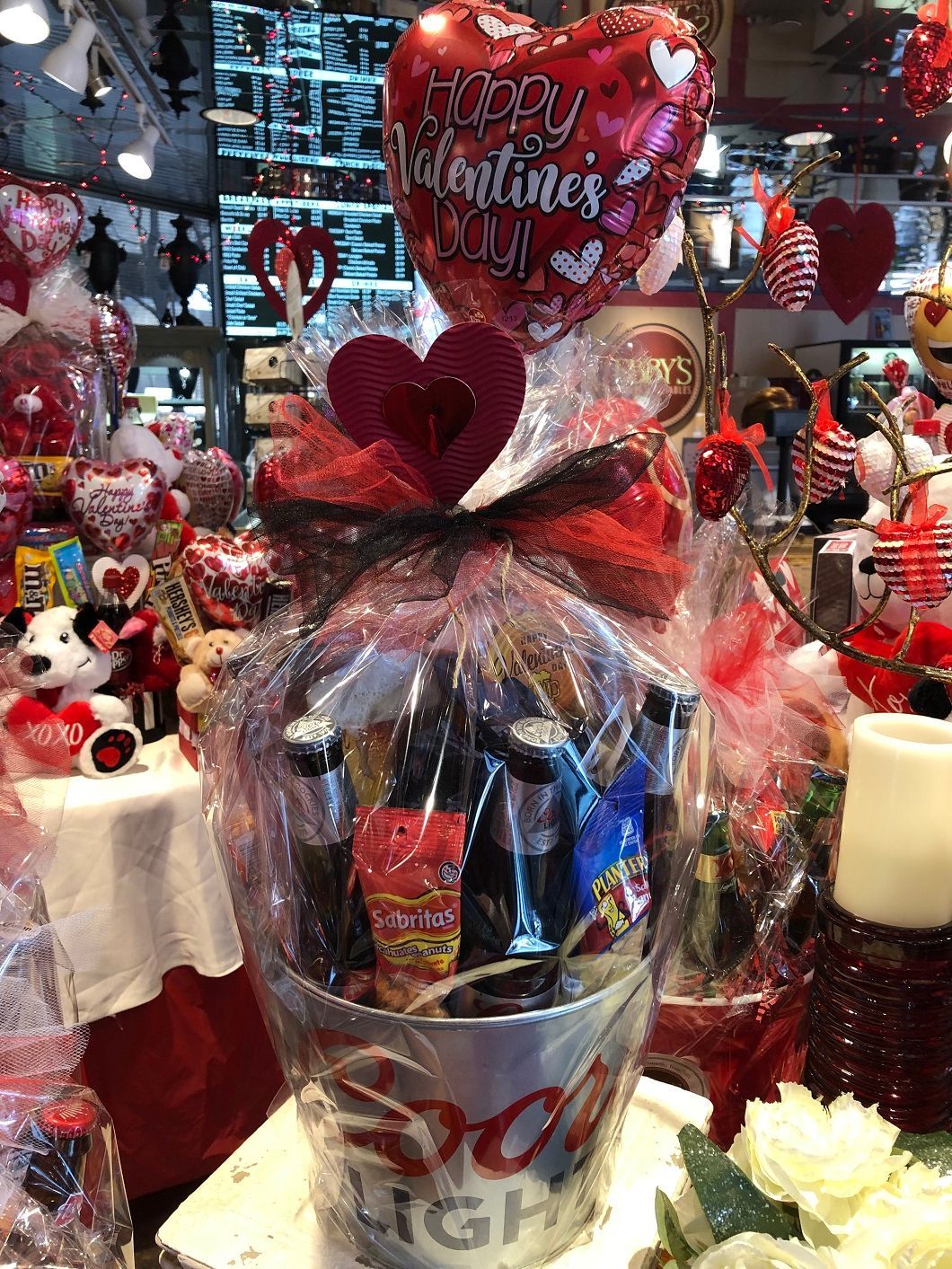 Valentine gift basket with heart balloons and red flowers in a decorated shop display