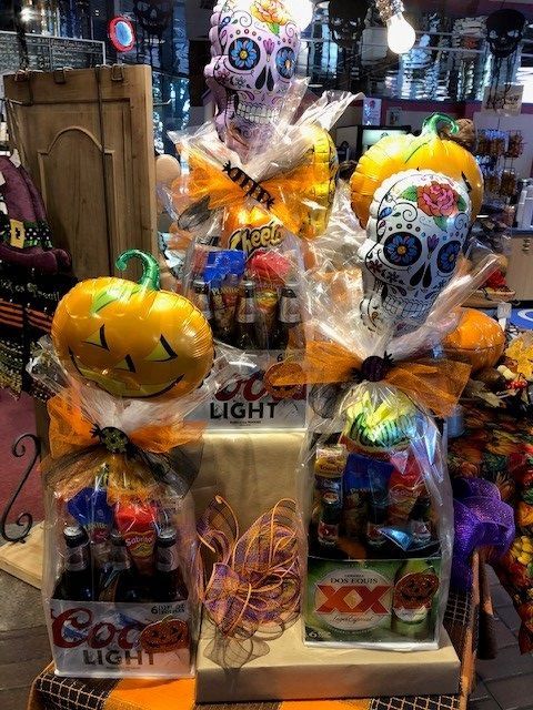 Halloween-themed gift display with colorful sugar skull balloons, a jack-o'-lantern balloon, and candy baskets