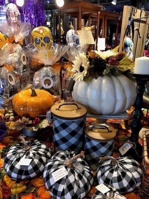 Halloween display with pumpkins, skull decor, and plaid-covered jars in orange, black, and white