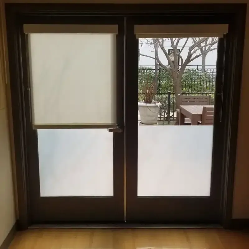A door with a view of a patio with a table and chairs
