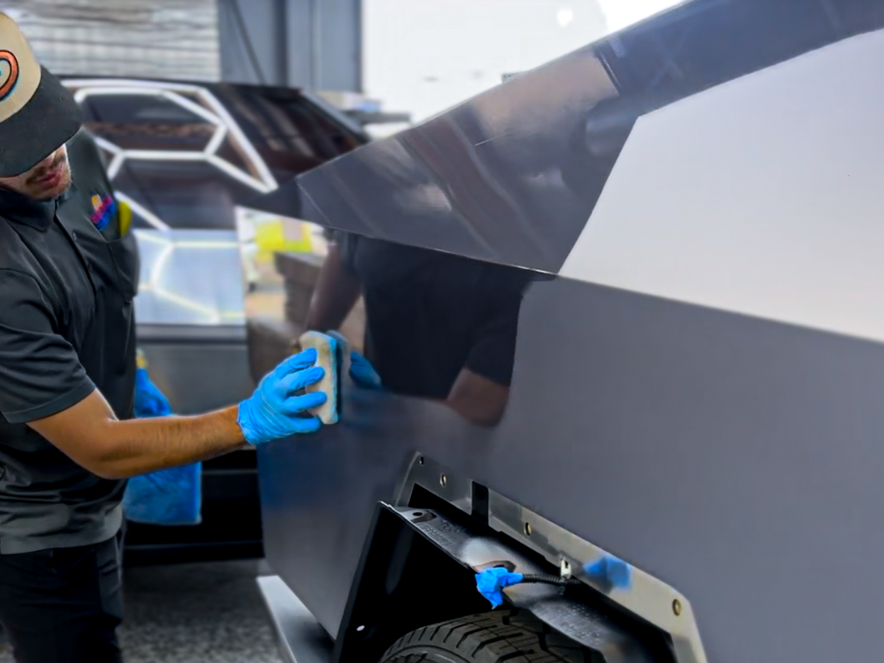 A man is polishing a car with a machine.