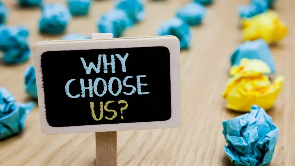 A sign that says `` why choose us '' is surrounded by crumpled paper balls.