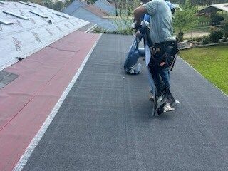 Two people riding a scooter on a sloped rooftop walkway, with greenery below.