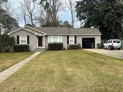Single-story suburban house with beige siding, a front lawn, driveway, and parked white SUV.