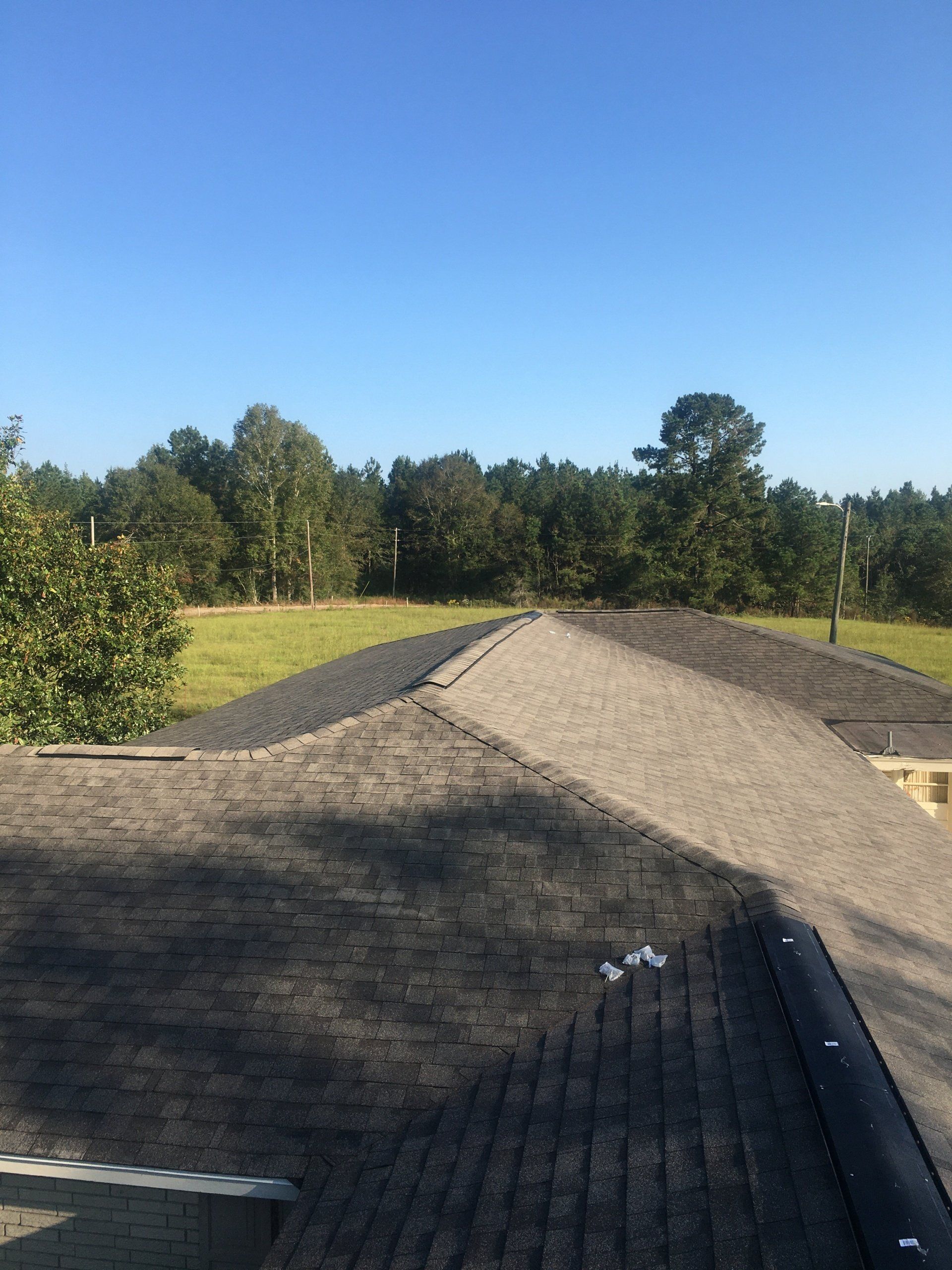 Gravel path across a grassy field under a clear blue sky, with trees in the background