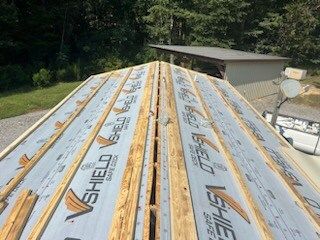 Roof with stacked SHELDMAX roofing panels on a house under construction outdoors