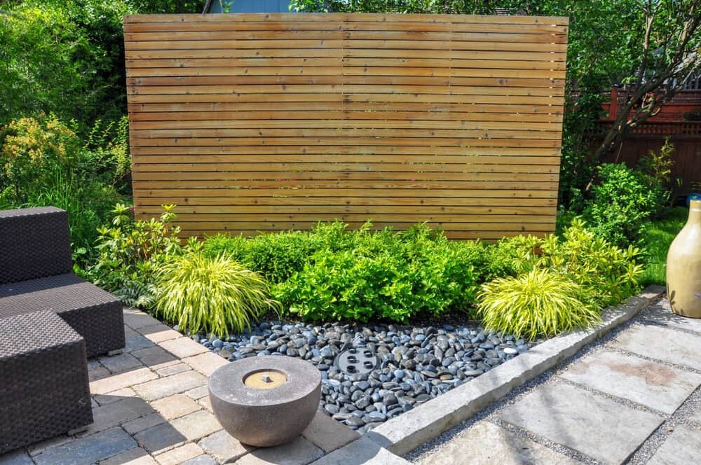 A Wooden Fence Is Surrounded By Plants And Rocks In A Garden — Pigot's Mid Western Sand and Soil In Orange, NSW